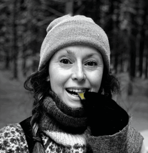 Outdoor winter portrait of the olympic gold medal winner Jamie Anderson. She is biting a piece of her VGAN matcha chocolate